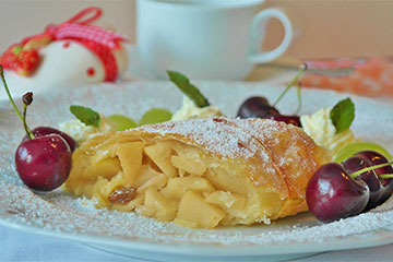 Apfelstrudel, © Pixabay Ein Apfelstrudel mit Kirschen garniert.
