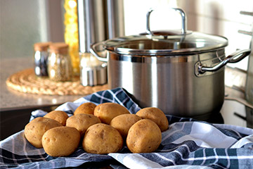 Erdäpfel, © Pixabay Erdäpfel neben einem Kochtopf.