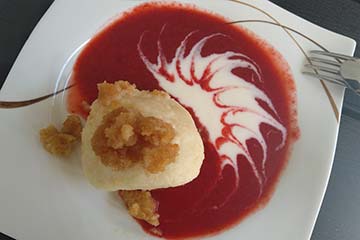 Topfenknödel, © Kaiser Topfenknödel serviert auf Erdbeerpüree.